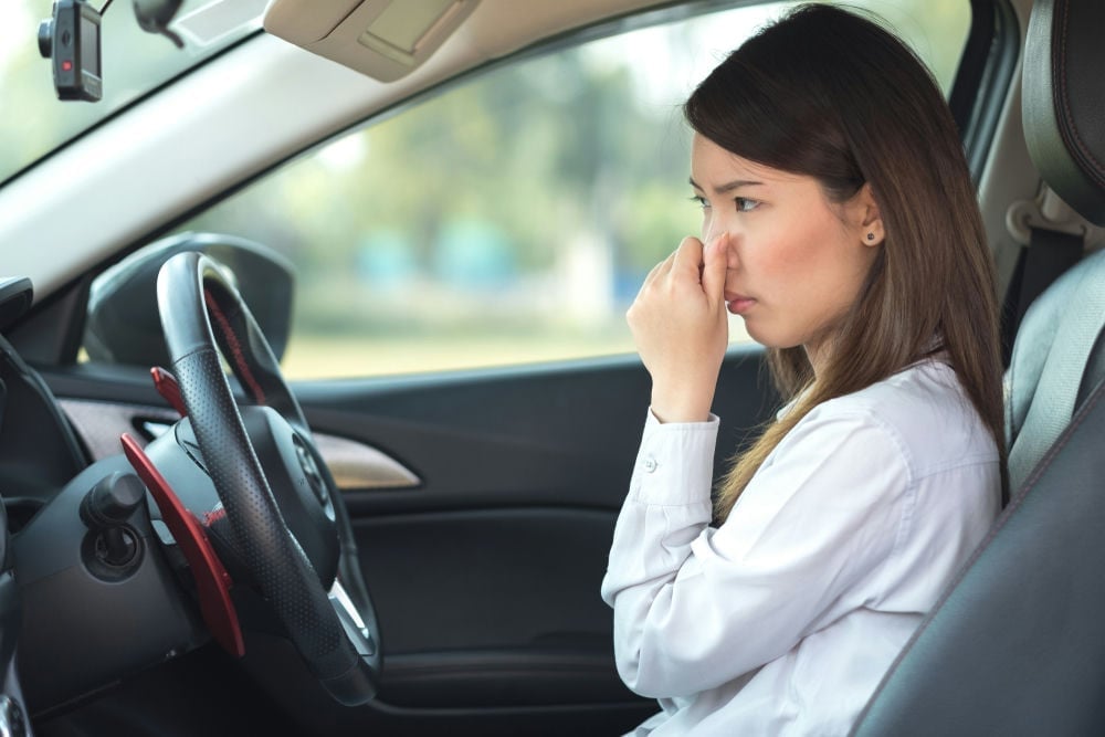 woman_smelling_exhaust_in_her_car_cab_shutterstock_1054476086