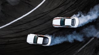 two_cars_drifting_on_a_track_shutterstock_1164902032