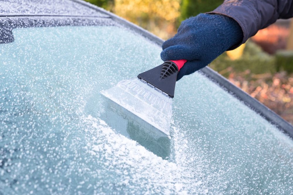 Using an ice scraper on a frosted windshield